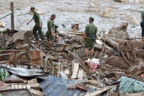 Lực lượng cứu hộ tìn kiếm tại chỗ khu vực sạt lở ở thôn 1, xã Trà Leng. (Ảnh: TTXVN phát)