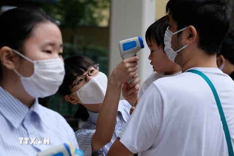 Đo thân nhiệt phòng lây nhiễm COVID-19 tại Tokyo, Nhật Bản. (Ảnh: AFP/TTXVN)