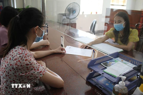 Nhân viên cục thuế tỉnh Ninh Bình hướng dẫn người dân làm thủ tục nộp thuế. (Ảnh: Hải Yến/TTXVN)
