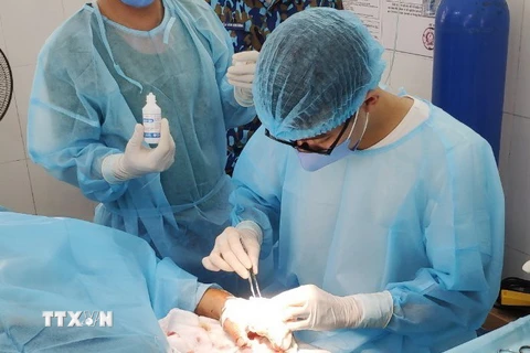 Các y, bác sỹ đảo Nam Yết đang xử lý vết thương cho bệnh nhân Nguyễn Văn Phúc. (Ảnh: TTXVN phát)