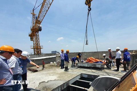 Lực lượng cưỡng chế cắt sàn mái tầng 18 công trình 8B Lê Trực, Hà Nội. (Ảnh: Mạnh Khánh/TTXVN)