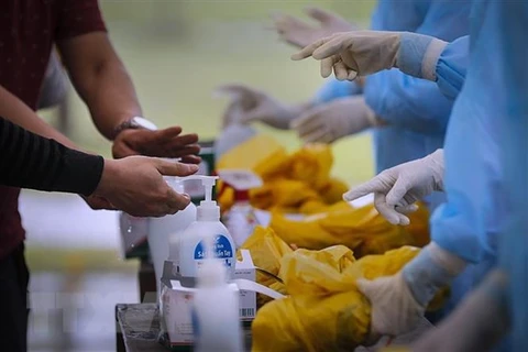 Các công dân Việt Nam từ nước ngoài trở về rửa tay bằng dung dịch khử trùng ngay khi về đến khu cách ly. (Ảnh: Trọng Đạt/TTXVN)
