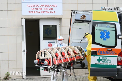 Nhân viên y tế chuyển bệnh nhân nhiễm COVID-19 tới bệnh viện ở Rome, Italy. (Ảnh: THX/TTXVN)