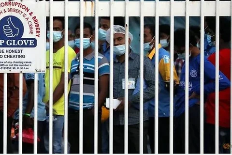 Công nhân xếp hàng chờ rời nhà máy Top Glove sau khi tan ca ở Klang, Malaysia ngày 7/12. (Nguồn: Reuters)