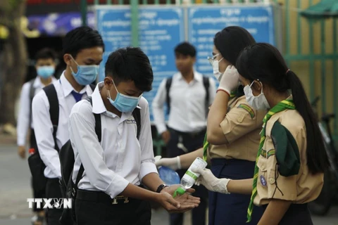 Các học sinh tiến hành sát khuẩn tay nhằm ngăn dịch COVID-19 lây lan, trước khi vào lớp ở Phnom Penh, Campuchia, ngày 2/11/2020. (Ảnh: AFP/TTXVN)