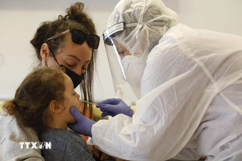 Nhân viên y tế lấy mẫu dịch xét nghiệm COVID-19 cho trẻ em tại Rishon Letzion, Israel, ngày 8/12/2020. (Ảnh: THX/TTXVN)