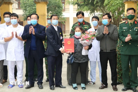 Lãnh đạo Trung tâm Y tế huyện Hoa Lư trao giấy ra viện cho bệnh nhân được chữa khỏi. (Ảnh: Đức Phương/TTXVN)