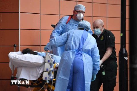 Chuyển bệnh nhân nhiễm COVID-19 tới bệnh viện ở London, Anh. (Ảnh: AFP/TTXVN)