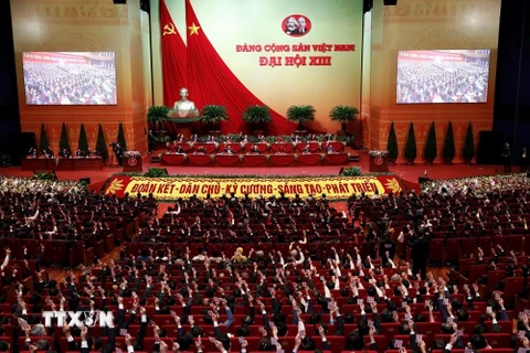 Các đại biểu biểu quyết, thông qua Nghị quyết Đại hội XIII Đảng Cộng sản Việt Nam. (Ảnh: TTXVN)