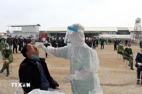 Bác sỹ lấy mẫu xét nghiệm SARS-CoV-2 cho cán bộ, người lao động làm việc, lao động tại Bắc Luân II, thành phố Móng Cái. (Ảnh: TTXVN)