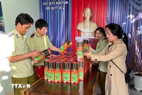 Đội Quản lý thị trường số 2 (Cục Quản lý thị trường tỉnh Kon Tum) kiểm tra các sản phẩm rượu giả nhãn mác thương hiệu rượu sâm Ngọc Linh Kon Tum K5. (Ảnh: TTXVN)