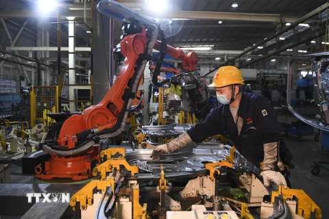 Công nhân làm việc bên trong một nhà máy ở Du Bắc, tỉnh Trùng Khánh, Trung Quốc ngày 11/3/2020. (Ảnh: THX/TTXVN)