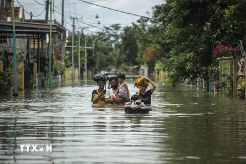Người dân Indonesia sơ tán khỏi khu vực ngập lụt ở Gresik, Đông Java ngày 15/12/2020. (Ảnh: AFP/TTXVN)