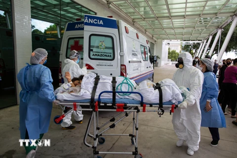 Nhân viên y tế chuyển bệnh nhân COVID-19 tới bệnh viện tại Manaus, bang Amazon, Brazil ngày 14/1/2021. (Ảnh: AFP/TTXVN)
