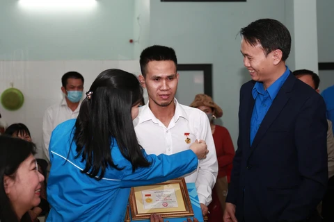 Đại diện Trung ương Đoàn trao tặng Huy hiệu "Tuổi trẻ dũng cảm" cho anh Nguyễn Ngọc Mạnh. (Ảnh: TTXVN phát)