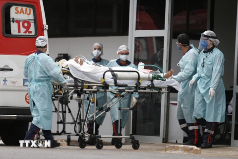 Nhân viên y tế chuyển bệnh nhân COVID-19 tới bệnh viện ở Brasilia, Brazil, ngày 11/3/2021. (Ảnh: THX/TTXVN)