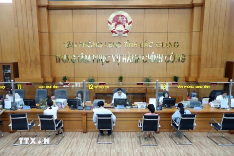 Tiếp nhận và giải quyết hồ sơ của các sở, ban, ngành tại Trung tâm Phục vụ hành chính công tỉnh Bắc Giang. (Ảnh: Danh Lam/TTXVN)