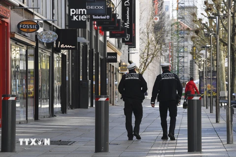 Nhân viên an ninh tuần tra gần Koeniggstrasse, một khu phố thương mại sầm uất ở Stuttgart, miền Nam Đức trong bối cảnh lệnh hạn chế được ban bố do dịch COVID-19. (Ảnh: AFP/TTXVN)