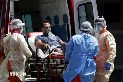 Nhân viên y tế chuyển bệnh nhân COVID-19 từ xe cứu thương vào một bệnh viện ở Brasilia, Brazil ngày 25/3/2021. (Ảnh: THX/TTXVN)