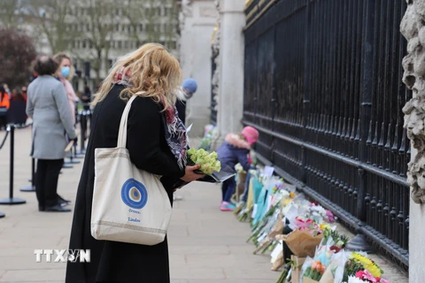 Người dân London đến đặt hoa tưởng niệm Hoàng thân Philip dọc theo cổng của Cung điện Buckingham. (Ảnh: Hải Vân/TTXVN)