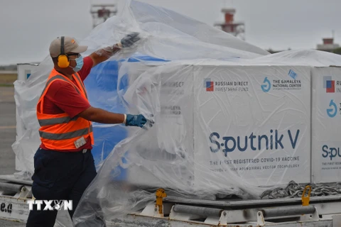 Nhân viên sân bay tháo dỡ lô vaccine ngừa COVID-19 Sputnik V của Nga tại sân bay quốc tế Simon Bolivar, Venezuela ngày 29/3/2021.(Ảnh: AFP/TTXVN)