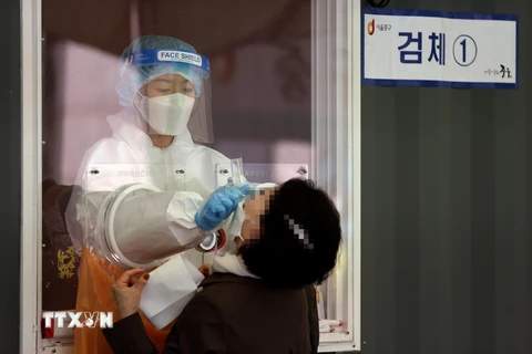 Nhân viên y tế lấy mẫu xét nghiệm COVID-19 cho người dân tại Seoul, Hàn Quốc, ngày 11/4/2021. (Ảnh: Yonhap/TTXVN)