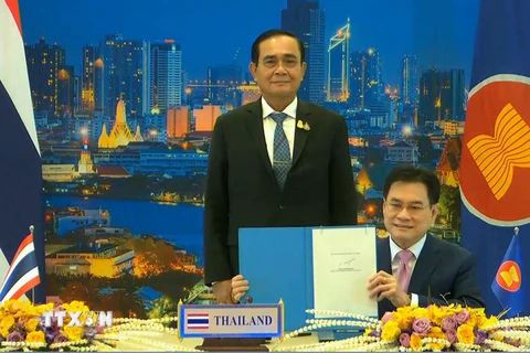 Thủ tướng Thái Lan Prayut Chan-O-Cha (trái) và Bộ trưởng Thương mại Jurin Laksanawisit (phải) tại lễ ký Hiệp định Đối tác kinh tế toàn diện khu vực (RCEP), trong khuôn khổ Hội nghị Thượng đỉnh ASEAN, ở Hà Nội, Việt Nam, ngày 15/11/2020. (Ảnh: AFP/TTXVN)