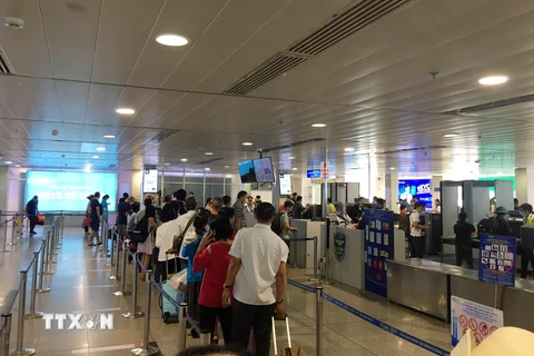 Hành khách làm thủ tục tại sân bay Tân Sơn Nhất. (Ảnh: Tiến Lực/TTXVN)