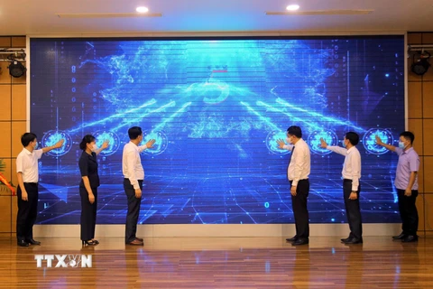 Các đại biểu thực hiện nghi thức khánh thành nâng cấp báo Quảng Ninh điện tử, ứng dụng Quảng Ninh Media trên nền tảng OTT và ra mắt bộ nhận diện thương hiệu Trung tâm với hình ảnh logo QMG. (Ảnh: Đức Hiếu/TXVN)
