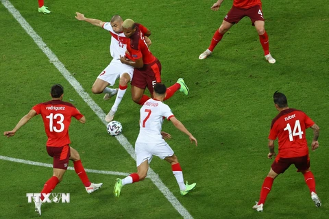 Pha tranh bóng quyết liệt của cầu thủ hai đội Thổ Nhĩ Kỳ (áo trắng) và Thụy Sĩ. (Ảnh: AFP/TTXVN)