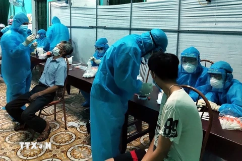 Nhân viên y tế lấy mẫu bệnh phẩm ngay trong đêm ở thôn Thanh Mai, xã An Thanh, huyện Quỳnh Phụ. (Ảnh: TTXVN phát)