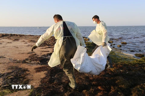 Nhân viên cơ quan bảo vệ dân sự Tunisia chuyển thi thể người di cư thiệt mạng do chìm thuyền tại Zarzis. (Ảnh: AFP/TTXVN)