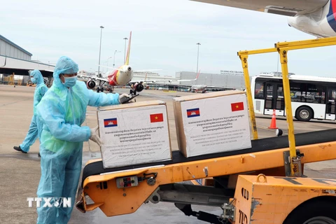 Vận chuyển hàng hỗ trợ của Chính phủ và nhân dân Campuchia từ máy bay ra xe hàng hóa hàng không chuyên dụng. (Ảnh: Xuân Khu-TTXVN)