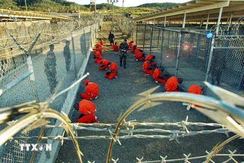  Các tù nhân bị giam giữ dưới sự giám sát của cảnh sát quân sự Mỹ tại nhà tù quân sự Guantanamo ngày 11/1/2002. (Ảnh: AFP/TTXVN)