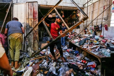 Người dân thu dọn các mảnh vỡ tại hiện trường xảy ra vụ nổ ở thành phố Sadr của Baghdad (Nguồn: Reuters)