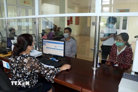 Người dân đến đăng ký mua thẻ bảo hiểm y tế tại Bảo hiểm xã hội huyện Yên Châu, tỉnh Sơn La. (Ảnh: Hữu Quyết/TTXVN)