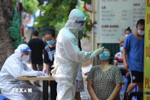 Lực lượng y tế quận Hai Bà Trưng, Hà Nội lấy mẫu xét nghiệm cho người dân phố Tô Hiến Thành. (Ảnh: Hoàng Hiếu/TTXVN)
