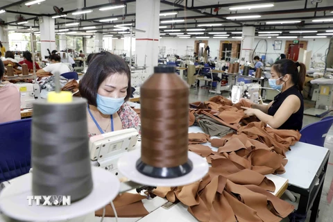 May hàng mẫu cho các hãng thời trang nước ngoài tại Công ty Maxport Hạ Đình, Thanh Xuân, Hà Nội. (Ảnh: Trần Việt/TTXVN)