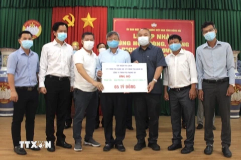 Đại diện Tập đoàn Pouchen (Đồng Nai) trao 5 tỷ đồng ủng hộ Quỹ vaccine phòng, chống dịch COVID-19. (Ảnh: TTXVN phát)