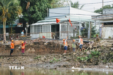 Thi công công trình kè chống sạt lở rạch Cái Sơn, quận Ninh Kiều, Cần Thơ. (Ảnh: Thanh Liêm/TTXVN)