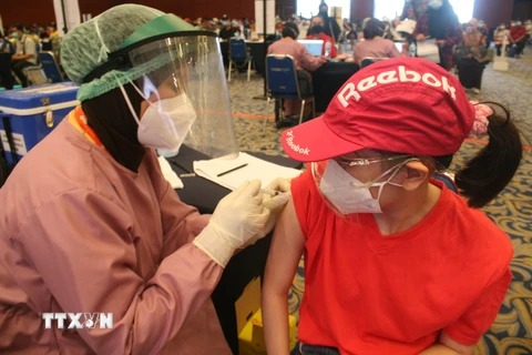 Nhân viên y tế tiêm vaccine phòng COVID-19 cho sinh viên tại Surabaya, Đông Java, Indonesia, ngày 4/8/2021. (Ảnh: THX/TTXVN)