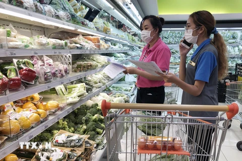 Nhân viên siêu thị giúp người dân đi chợ online tại TP Hồ Chí Minh. (Ảnh: Mỹ Phương/TTXVN)