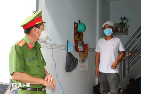Lực lượng công an huyện Bến Lức thăm hỏi, động viên công nhân khu nhà trọ xã Tân Bửu. (Ảnh: Thanh Bình/TTXVN)