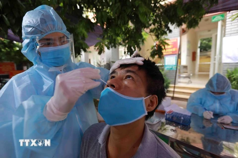 Nhân viên y tế lấy mẫu xét nghiệm cho người dân phường Tây Mỗ, quận Nam Từ Liêm, Hà Nội. (Ảnh: Vũ Sinh/TTXVN)