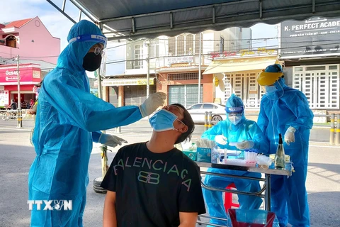 Nhân viên y tế lấy mẫu xét nghiệm cộng đồng cho người dân ở Khu vực 2, phường Hưng Lợi, quận Ninh Kiều. (Ảnh: Thu Hiền/TTXVN)