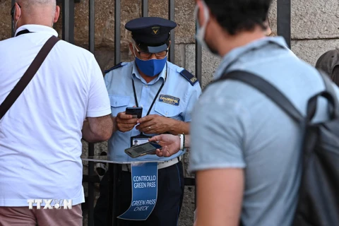 Nhân viên an ninh kiểm tra chứng nhận COVID-19 của khách tham quan tại Rome, Italy, ngày 6/8/2021. (Ảnh: AFP/TTXVN)