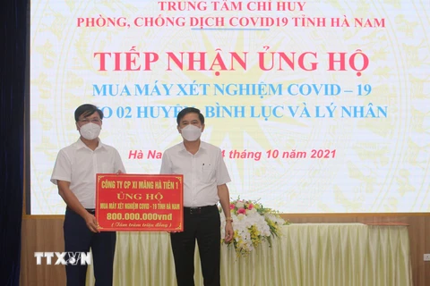 Phó Chủ tịch UBND tỉnh Hà Nam Trần Xuân Dưỡng tiếp nhận ủng hộ của các doanh nghiệp. (Ảnh: Thanh Tuấn/TTXVN)
