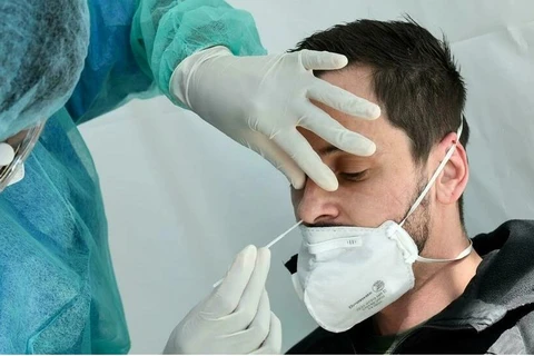 Bác sỹ đang tiến hành xét nghiệm COVID-19 cho người dân tại một trung tâm y tế ở Paris. (Nguồn: AFP)