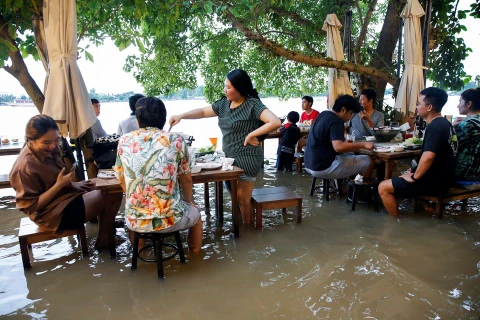 Thực khách dùng bữa tại một nhà hàng trên nước lũ ở nhà hàng ven sông ở Nonthaburi gần Bangkok. (Nguồn: Reuters)