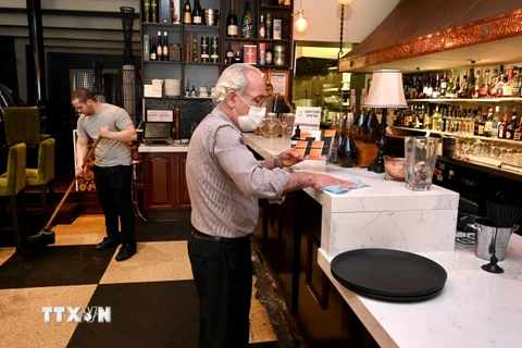 Một nhà hàng tại thành phố Melbourne, Australia chuẩn bị cho việc mở cửa trở lại, ngày 21/10/2021. (Ảnh: AFP/TTXVN)